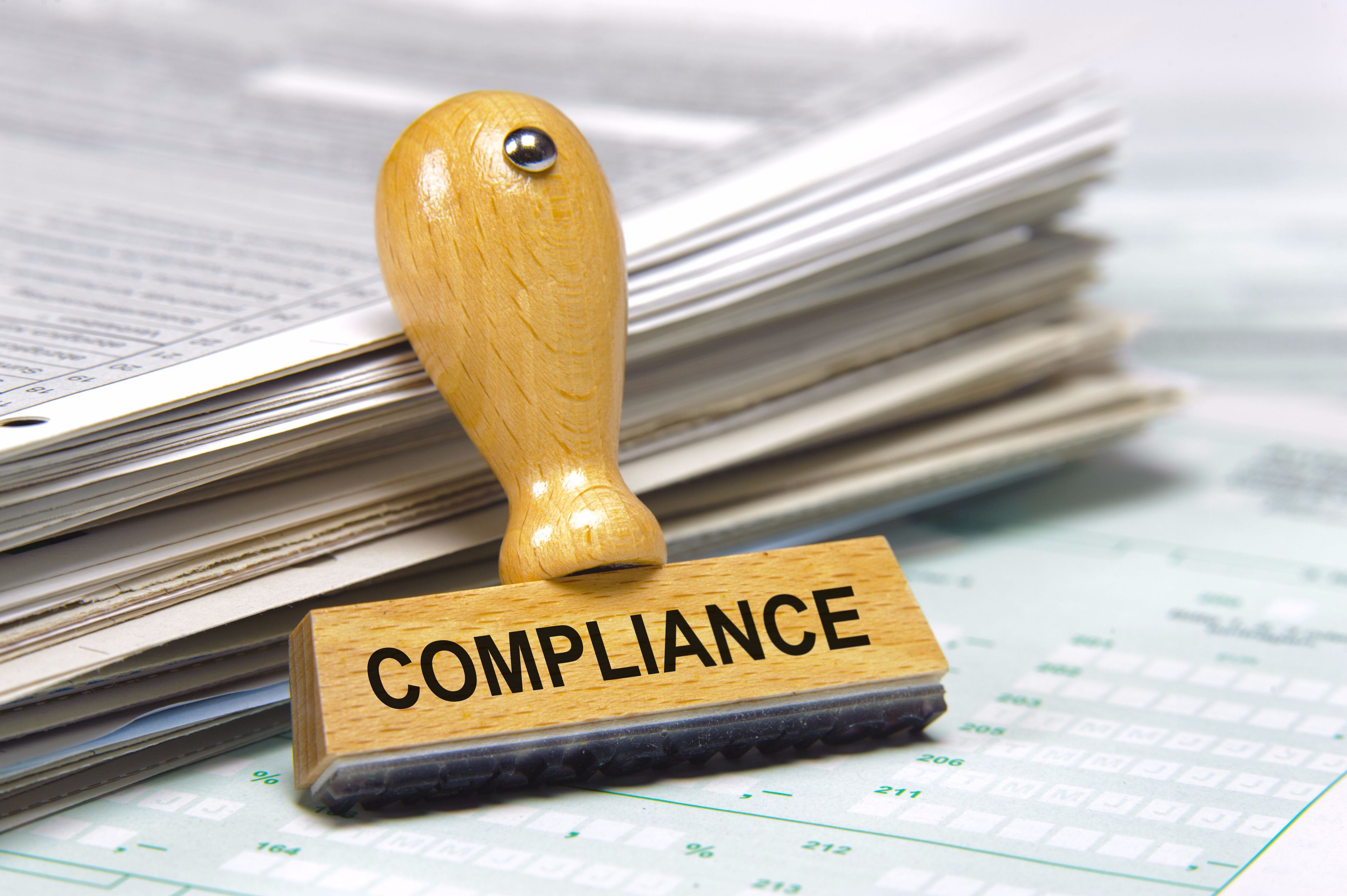 Compliance stamp affixed to a collection of official tax documents and forms.